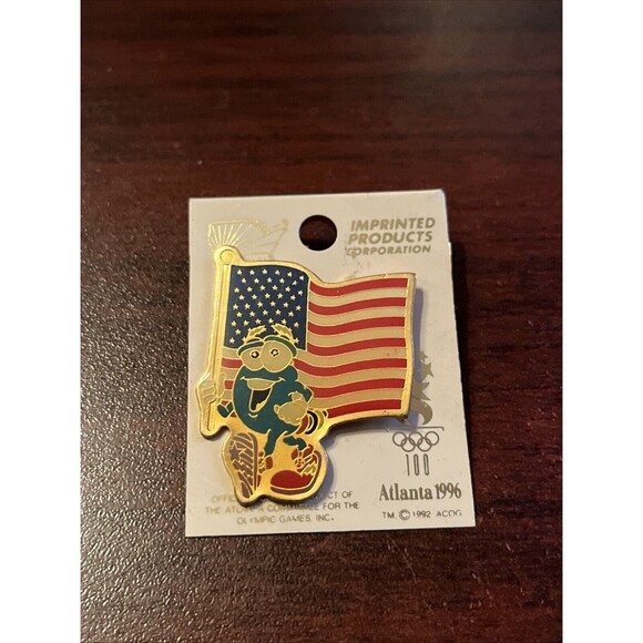 Vintage 1996 Atlanta Summer Olympics Izzy Mascot‎ Carrying American Flag Hat Pin - Picture 1 of 3